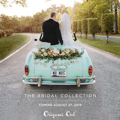 a bride and groom sitting on the back of an old car with their arms in the air