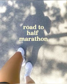 someone is standing on the sidewalk with their feet in front of a sign that reads road to half marathon