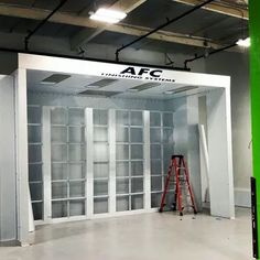 an empty room with glass doors and ladders on the floor in front of it