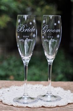 two wine glasses sitting on top of a doily next to each other with the word bride and groom written on them