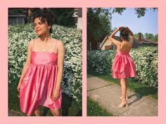 a woman in a pink dress is standing on the sidewalk and looking at her hair