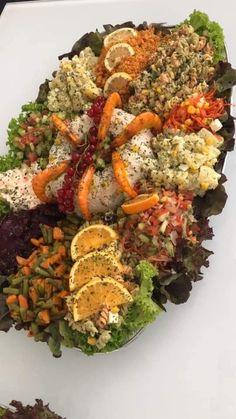 a large platter filled with lots of different types of food on top of a white table