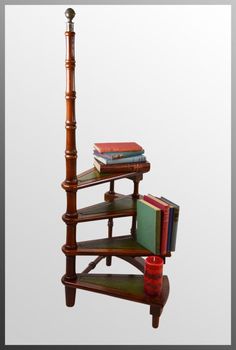 three books are stacked on top of each other near a book shelf with a candle