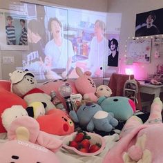 several stuffed animals sitting on top of a bed next to a bowl of strawberries