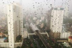 rain drops on a window with cityscape in the background as seen from an office building