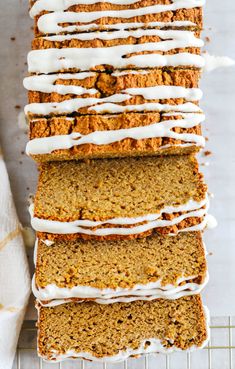 sliced carrot bread with white icing on a cooling rack