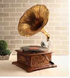 an old fashioned record player sitting on top of a wooden table next to a brick wall