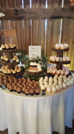 a table topped with lots of cupcakes and pastries