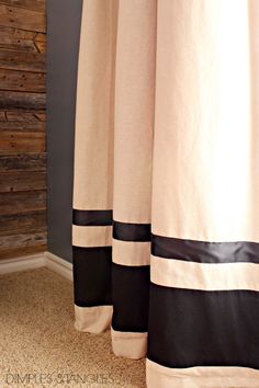 a bathroom with a shower curtain that has black and white stripes on the bottom half of it