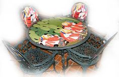 a table and four chairs with designs on the top, sitting in front of a white background