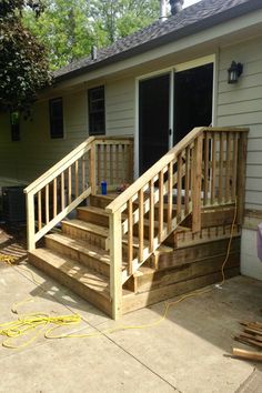 a wooden porch with steps leading up to the front door