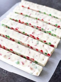 white chocolate covered with candy canes on top of a piece of parchmented paper