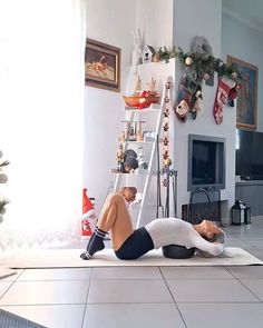 a man and woman are doing yoga in the living room