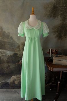 "Everyone will be green with envy when they see you in this lovely retro vintage 60s maxi dress! It is perfect for any Jane Austen fan with its Regency era silhouette. The color is a beautiful green sorbet. Darling eyelet lace is featured on the puff sleeves. It has an empire waist, with a zipper in the back and ties. It is in pristine condition.  Brand: Union Made  No noticeable flaws Size: Approximately modern Small Measurements:  19\" underarm to underarm  16\" empire waist 10\" sleeve length  6\" arm opening 54.5\" length *All vintage items are FINAL SALE. Please email with any questions before purchasing. We are happy to help with any inquires! *Please note that though we look over each vintage and antique item extensively and note flaws in descriptions, these are still aged items of Fitted Green Maxi Dress With Empire Waist, Green Retro Vintage Dress, Fitted Green Maxi Dress For Daywear, 1970s Fitted Green Maxi Dress, 1970s Style Fitted Green Maxi Dress, Fitted 1970s Style Green Maxi Dress, Green Retro Vintage Dress With Short Sleeves, Green Fitted Maxi Dress 1970s Style, Retro Green Vintage Dress For Daywear