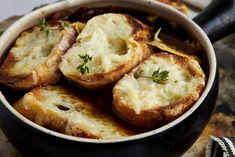 some bread is in a pot with sauce and parmesan cheese on the side