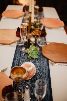 a long table is set with place settings for dinner guests to sit down and eat