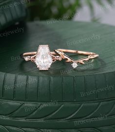 two wedding rings on top of a green tire with greenery in the back ground