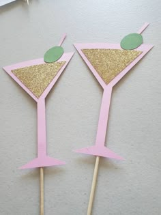 two pink and gold cocktail glasses on sticks