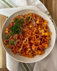 a white bowl filled with pasta covered in sauce and parmesan cheese