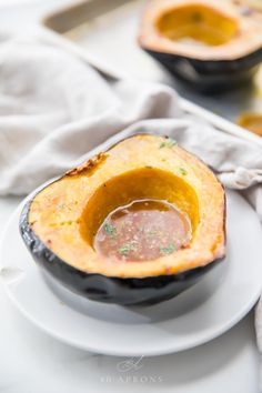 a white plate topped with an acorn filled with soup