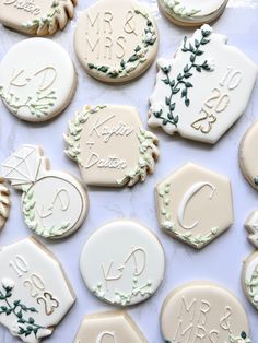 decorated cookies are arranged on a table with white frosting and green trimmings