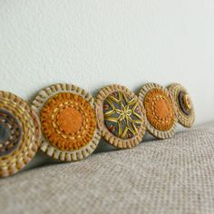 four decorative objects are lined up on the wall, one is orange and the other is brown