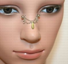 a mannequin's head with a nose chain attached to the nose and eyes