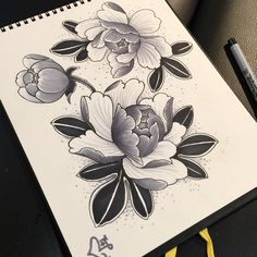 a drawing of some flowers on a piece of paper next to a pen and marker