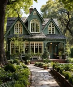 a green house surrounded by trees and bushes