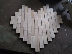 a heart made out of wooden pieces on top of a table