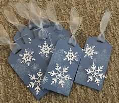 four tags with snowflakes on them sitting on the floor