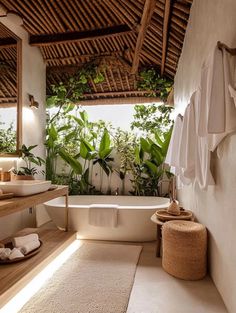 a bathroom with a bathtub, sink and plants on the wall above it in front of a mirror