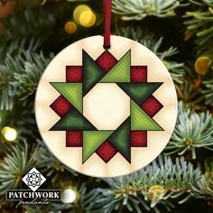 a christmas ornament hanging from a tree decorated with green and red geometric shapes