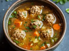 a bowl filled with meatball soup on top of a table