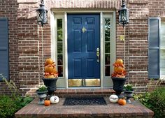 pumpkins and gourds are sitting on the front steps