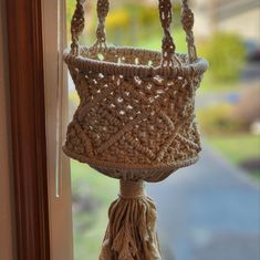 a crocheted purse hanging from a window sill