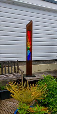 a stained glass window sitting on top of a wooden bench in front of a building