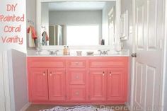 a bathroom with pink cabinets and white walls