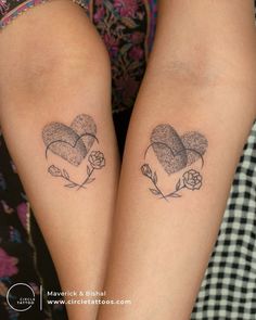 two people with matching tattoos on their legs, one has a heart and the other has a flower