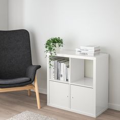 a white book shelf with books and a black chair in the corner next to it