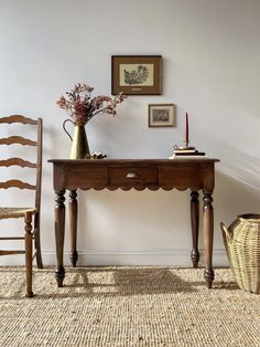 a wooden table with two chairs next to it and a vase filled with flowers on top