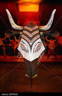 an animal's head on display in front of a wall with paintings and lights