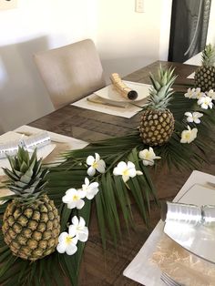 pineapples and white flowers are arranged on the table