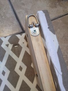 a pair of scissors sitting on top of a piece of wood next to a rug