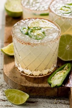 two margaritas on a cutting board with lime slices