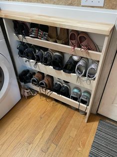 a washer and dryer in a small room with shoes on the shelf next to it