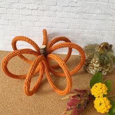 an orange flower sitting on top of a table next to some vases filled with flowers