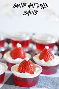 small cupcakes with whipped cream and strawberries in them on a checkered tablecloth