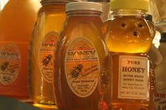 several jars of honey sit on a shelf