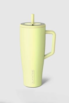 a yellow coffee cup with a lid and handle on a gray background is seen in this image